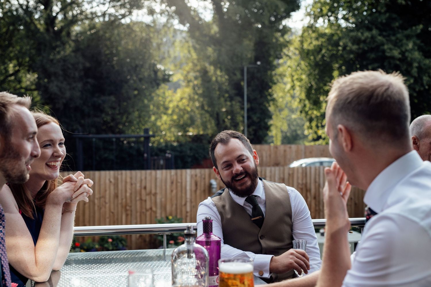 Wedding guests enjoying outdoor celebrations at a sunny garden reception.