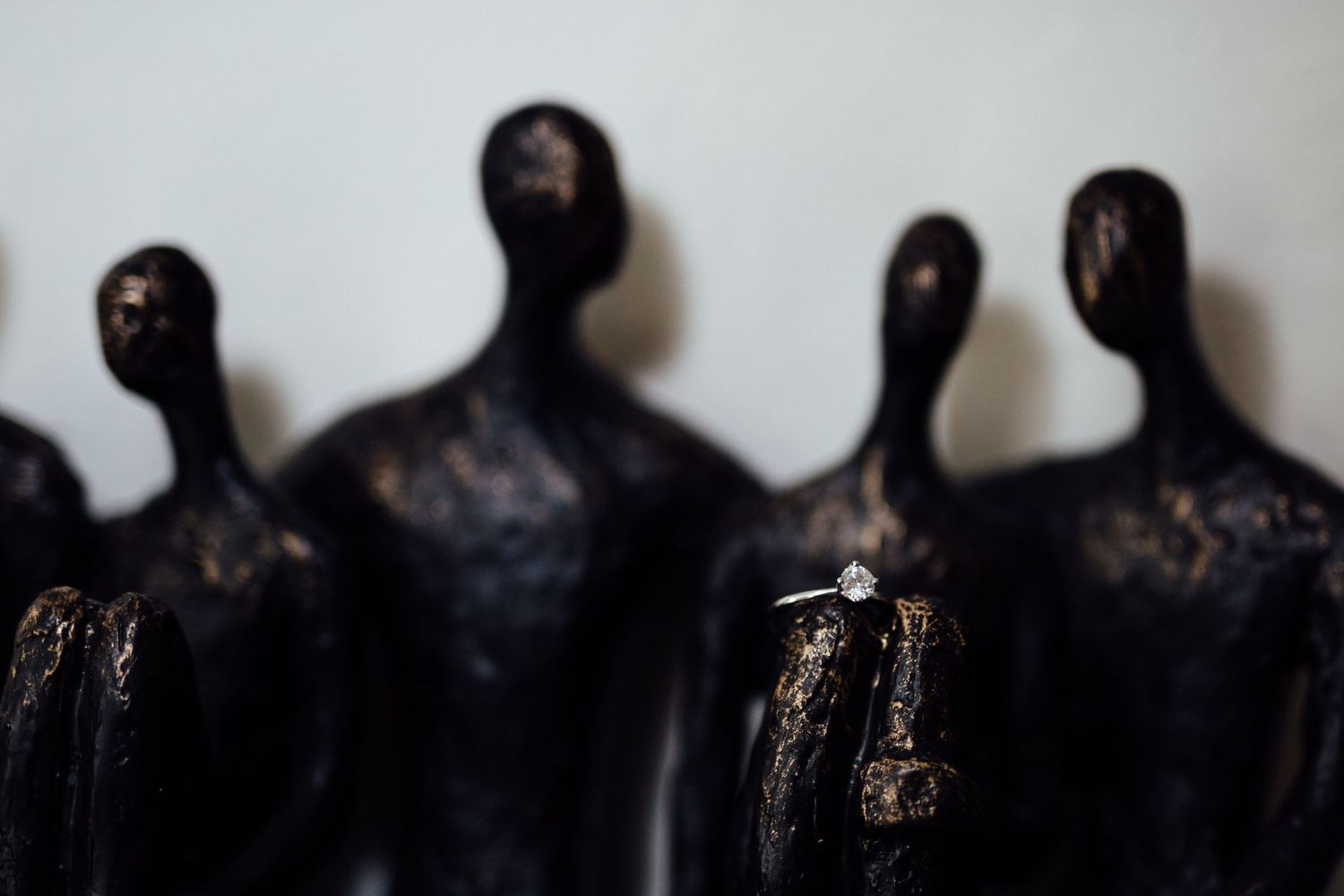 Artistic display of dark sculptural figures with dramatic lighting.