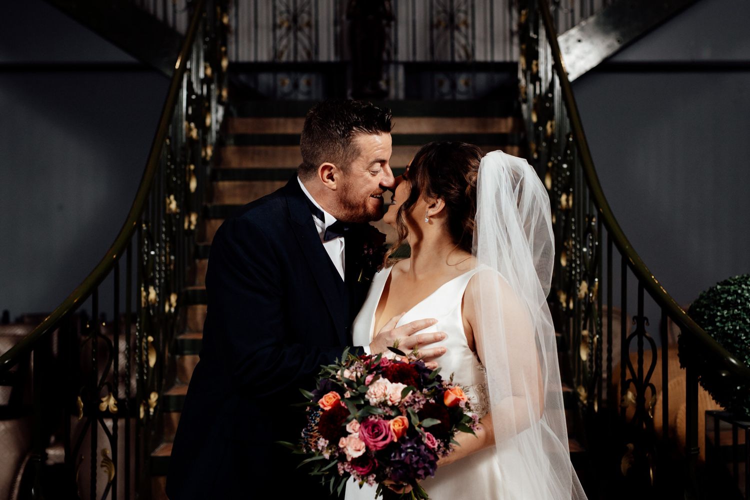 Dramatic evening wedding portraits with moody lighting and architectural elements.