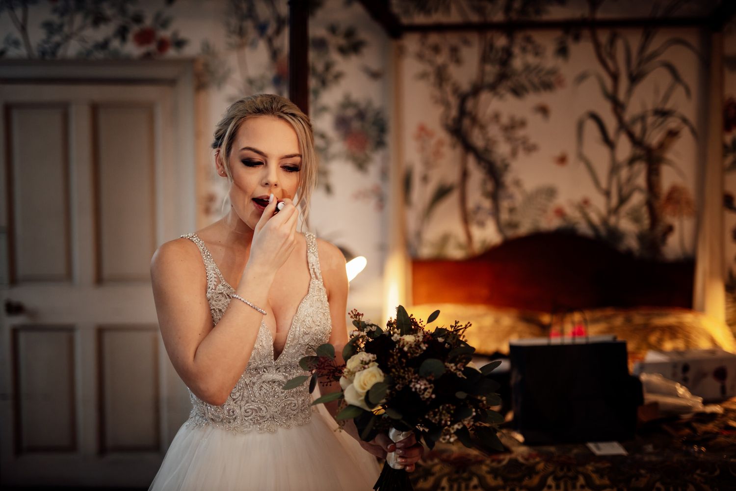 An emotional moment captured by the fireplace in an elegant room with floral wallpaper.