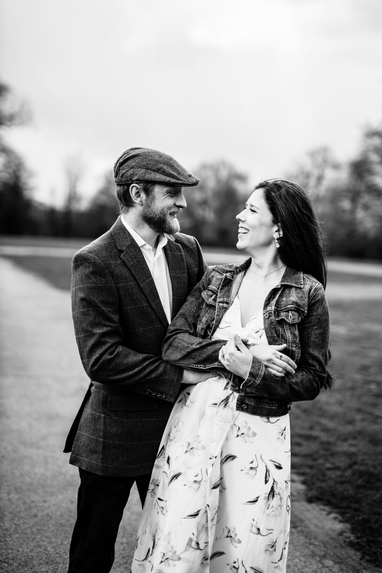 Black and white photo of a couple sharing a tender moment outdoors.