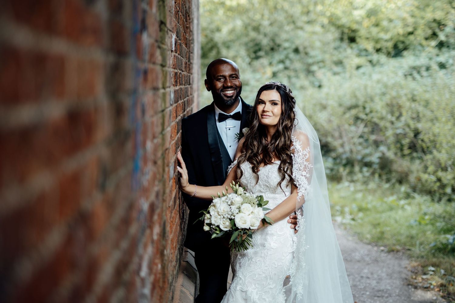 Romantic outdoor wedding portraits captured among trees and greenery.