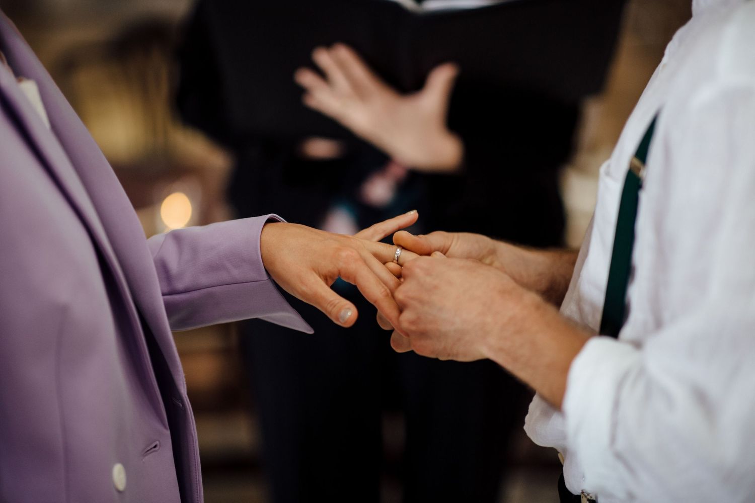 Hands gesturing during an animated conversation in purple-tinted lighting.