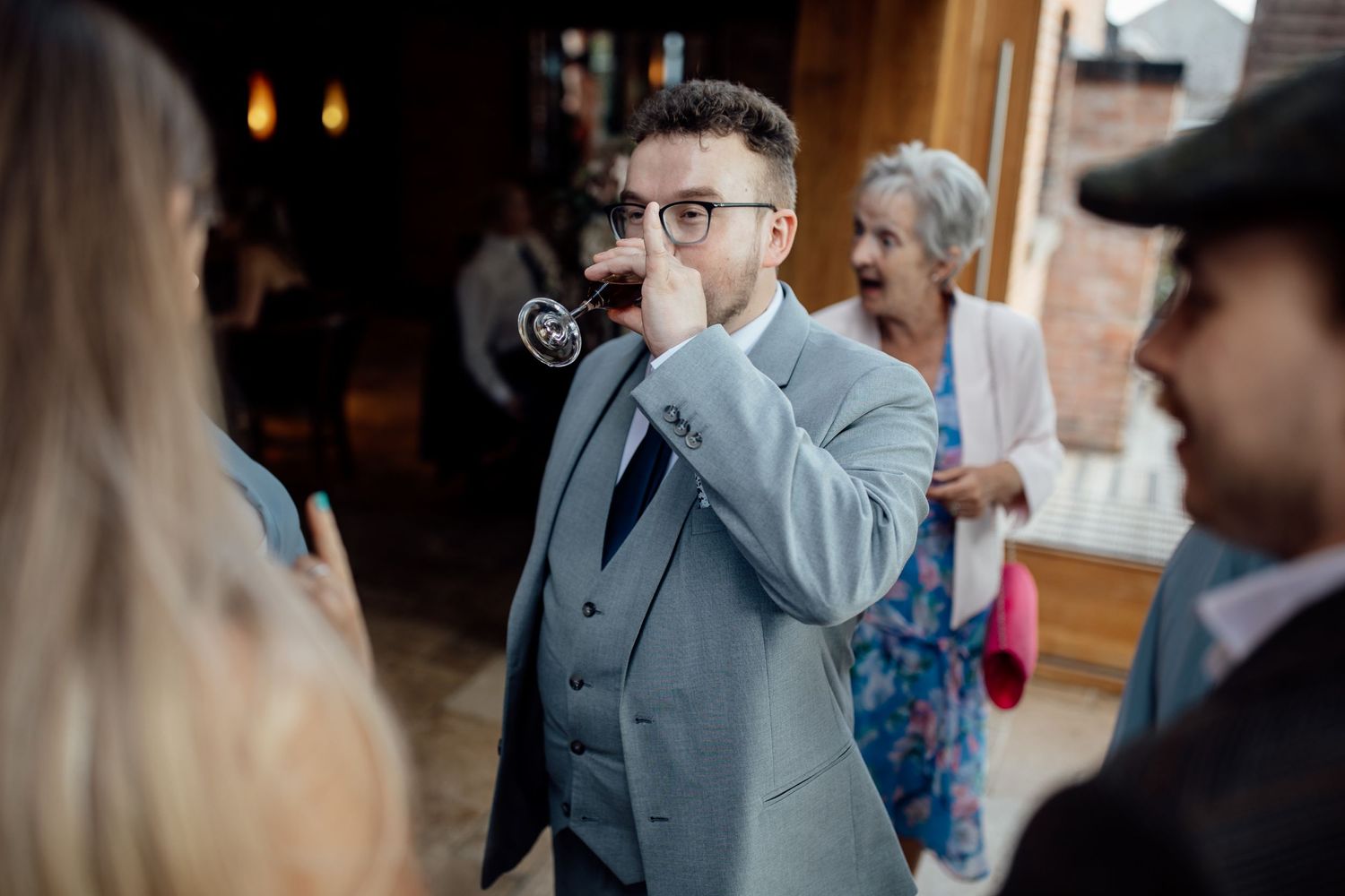 Wedding guests mingling and socializing during an indoor reception.
