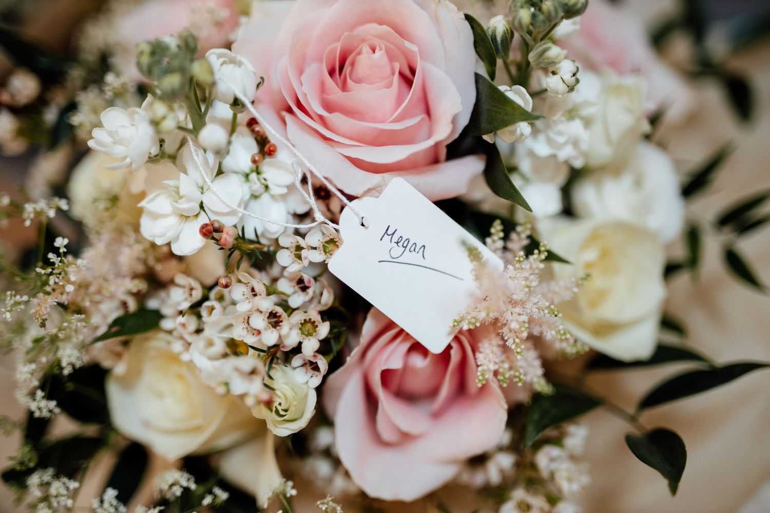 Delicate pink roses and white baby's breath arranged in elegant wedding centerpieces.