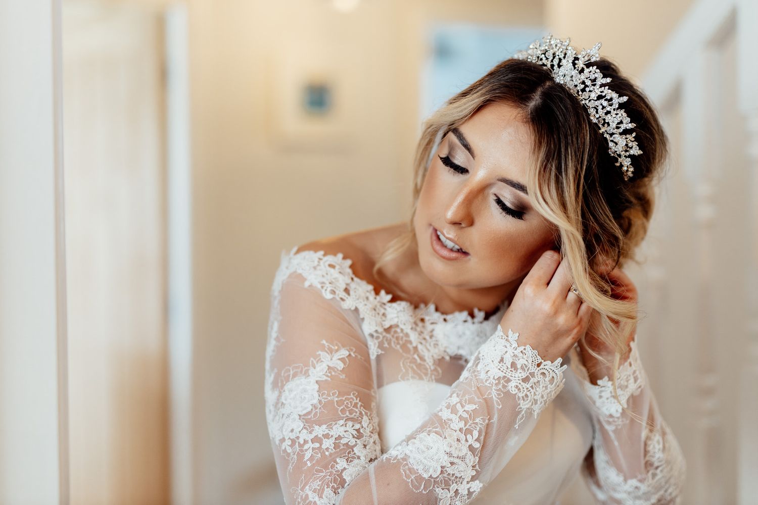 Elegant bridal portrait showcasing detailed lace dress and tiara.