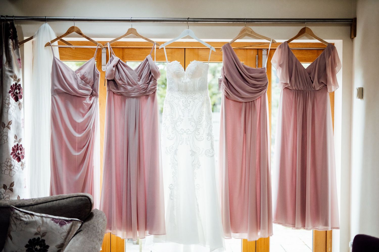 Elegant window treatments with pink and peach draped curtains in a wedding venue.