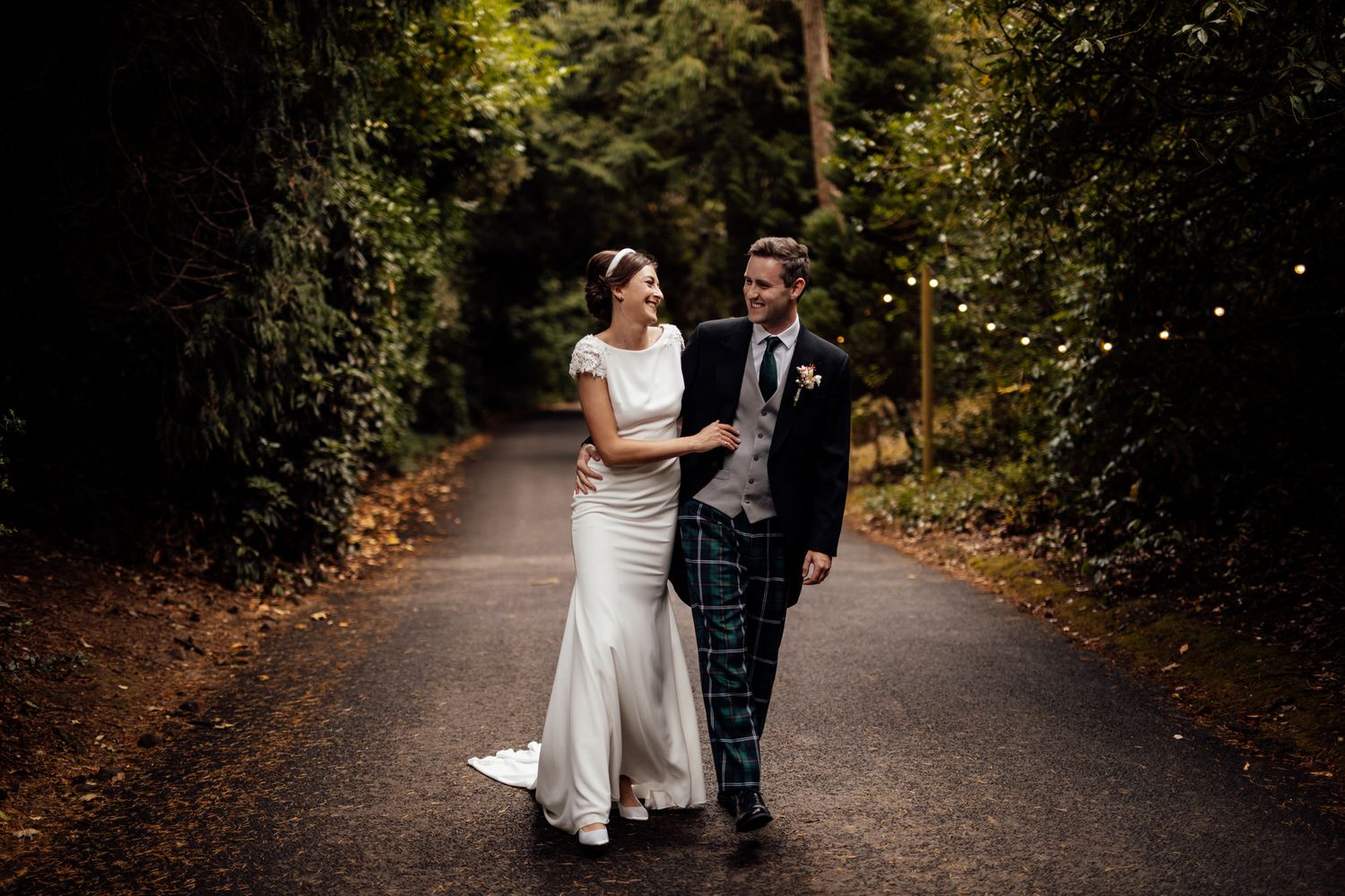 Couple sharing intimate moments during their wedding photoshoot on a forest path.