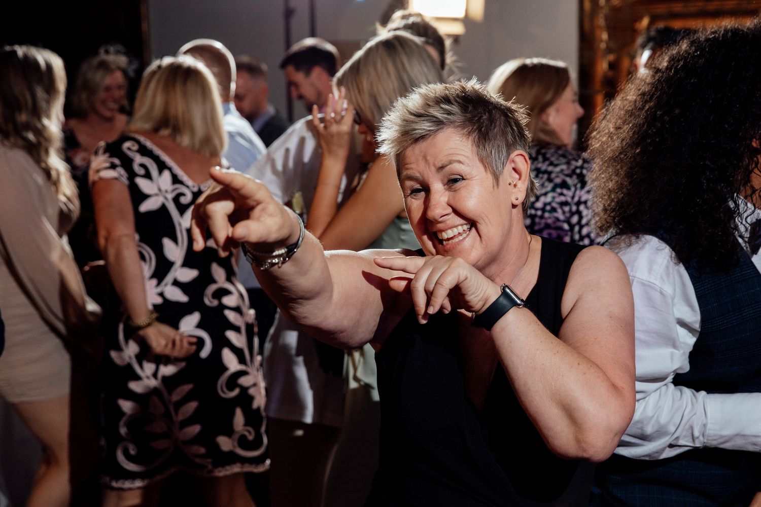 A guest dances enthusiastically on the dance floor at a wedding reception.