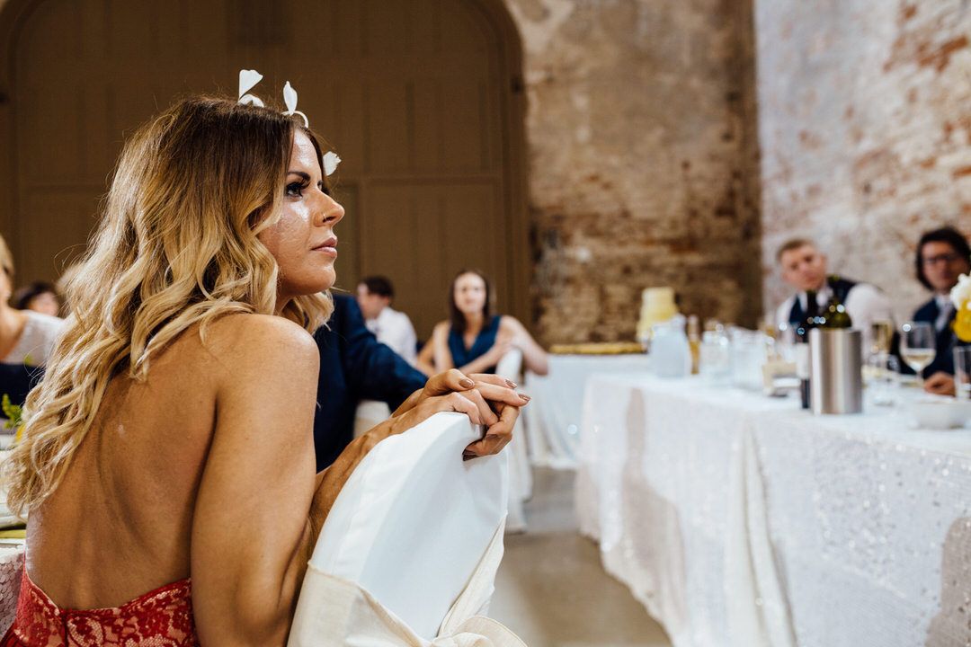 Rustic wedding venue interior with exposed brick walls and white table settings.