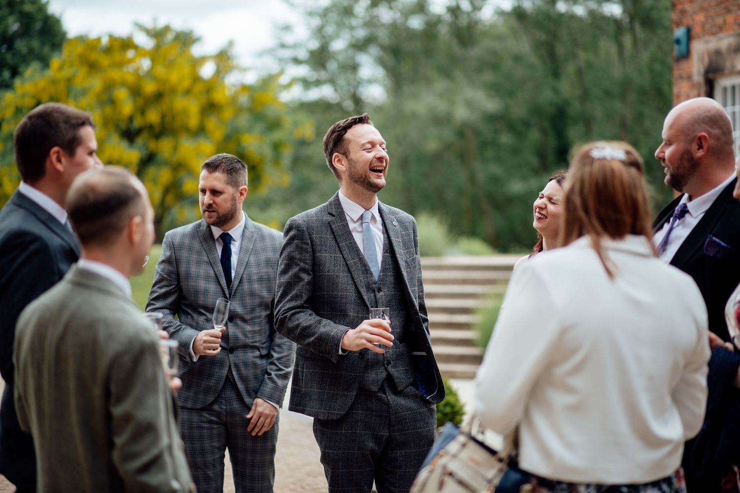 Wedding guests mingle and socialize during an outdoor cocktail reception.