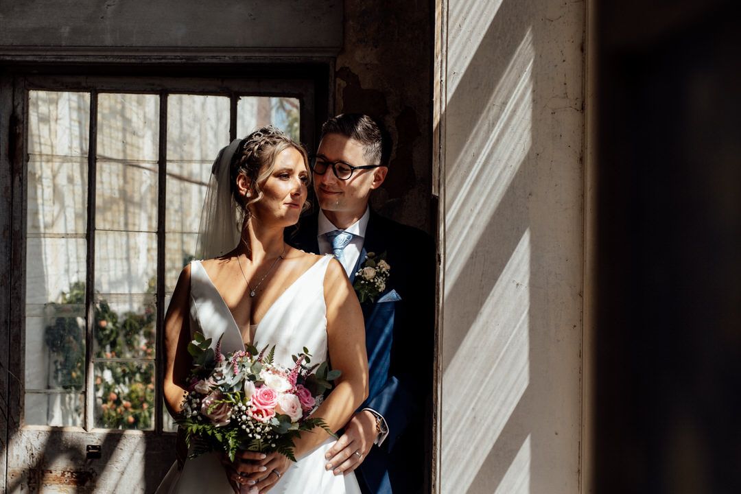 Romantic wedding portraits captured in dramatic window light and shadows.