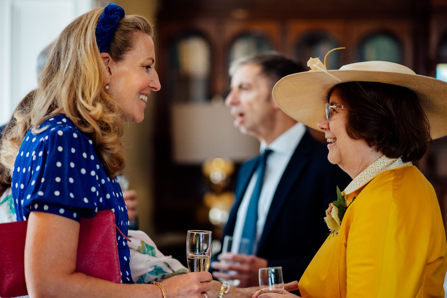 Wedding guests enjoying drinks and conversation at an elegant indoor reception.