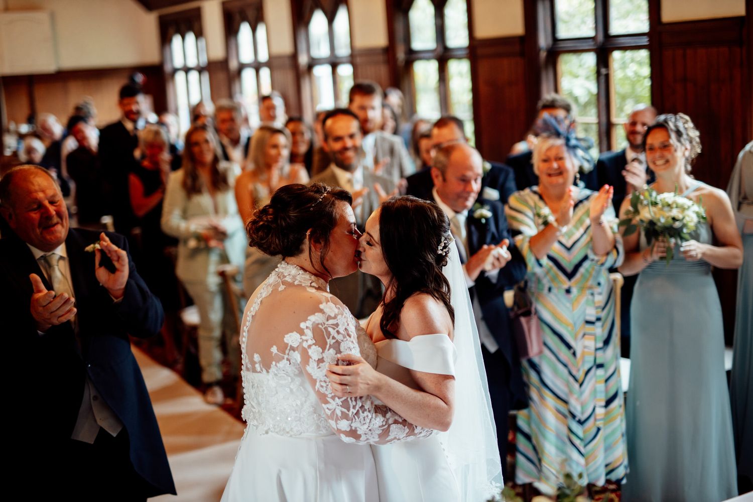 Wedding celebration in elegant venue with guests and blue bridesmaid dresses.