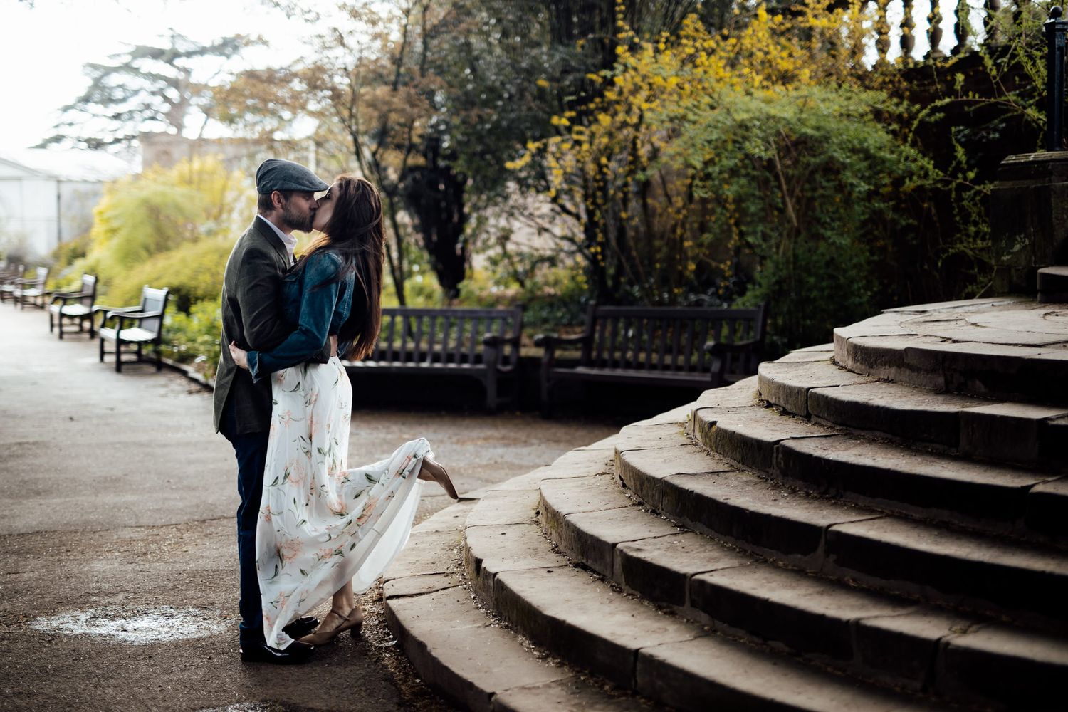 A romantic moment captured on stone steps in an urban garden setting.