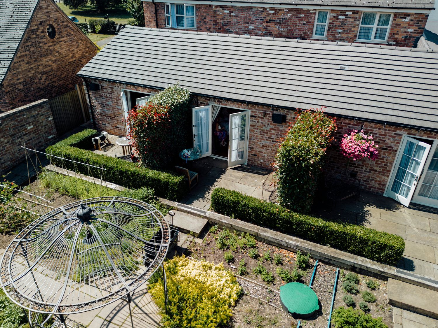 Aerial view of a brick building with manicured gardens and pathways.