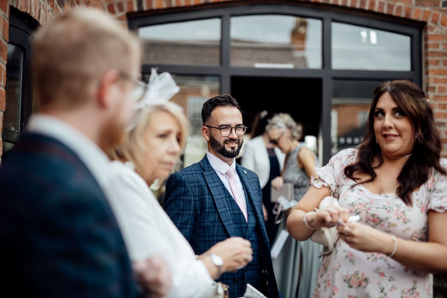 Wedding guests mingle and celebrate during an outdoor brick-venue reception.