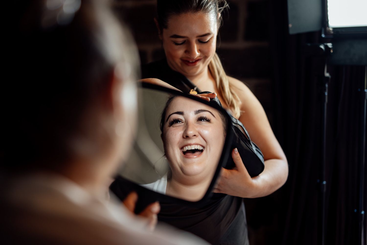 Getting ready moment with joyful laughter during wedding preparations.
