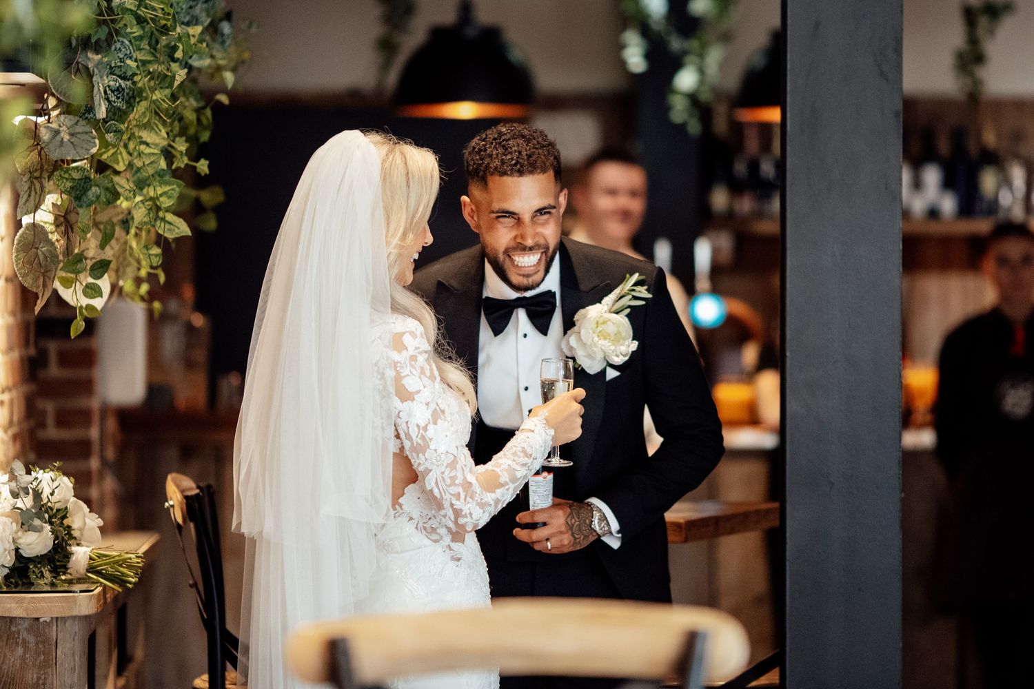 Wedding reception venue decorated with greenery and floral arrangements.