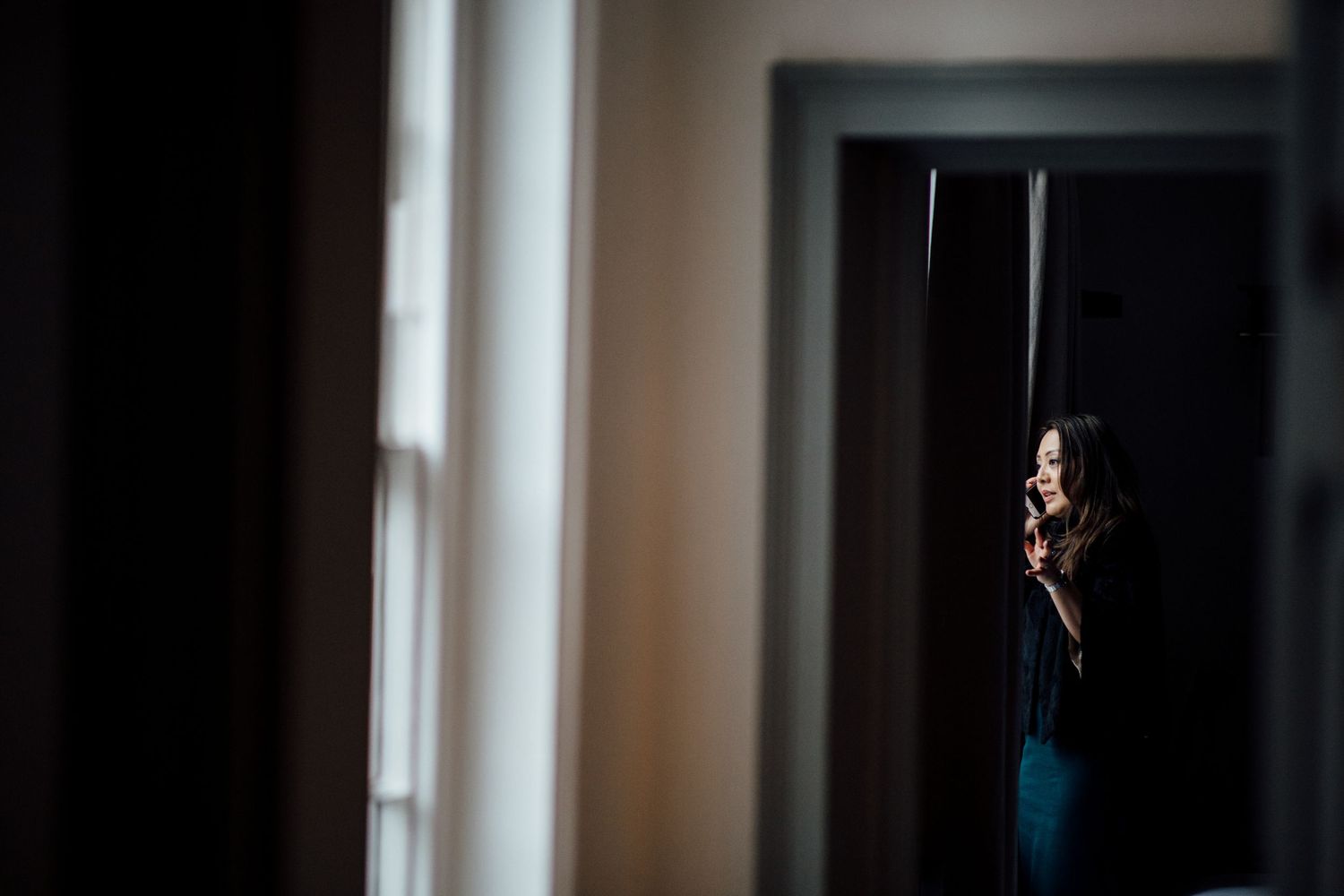 Elegant window lighting creates dramatic shadows in an indoor wedding venue.