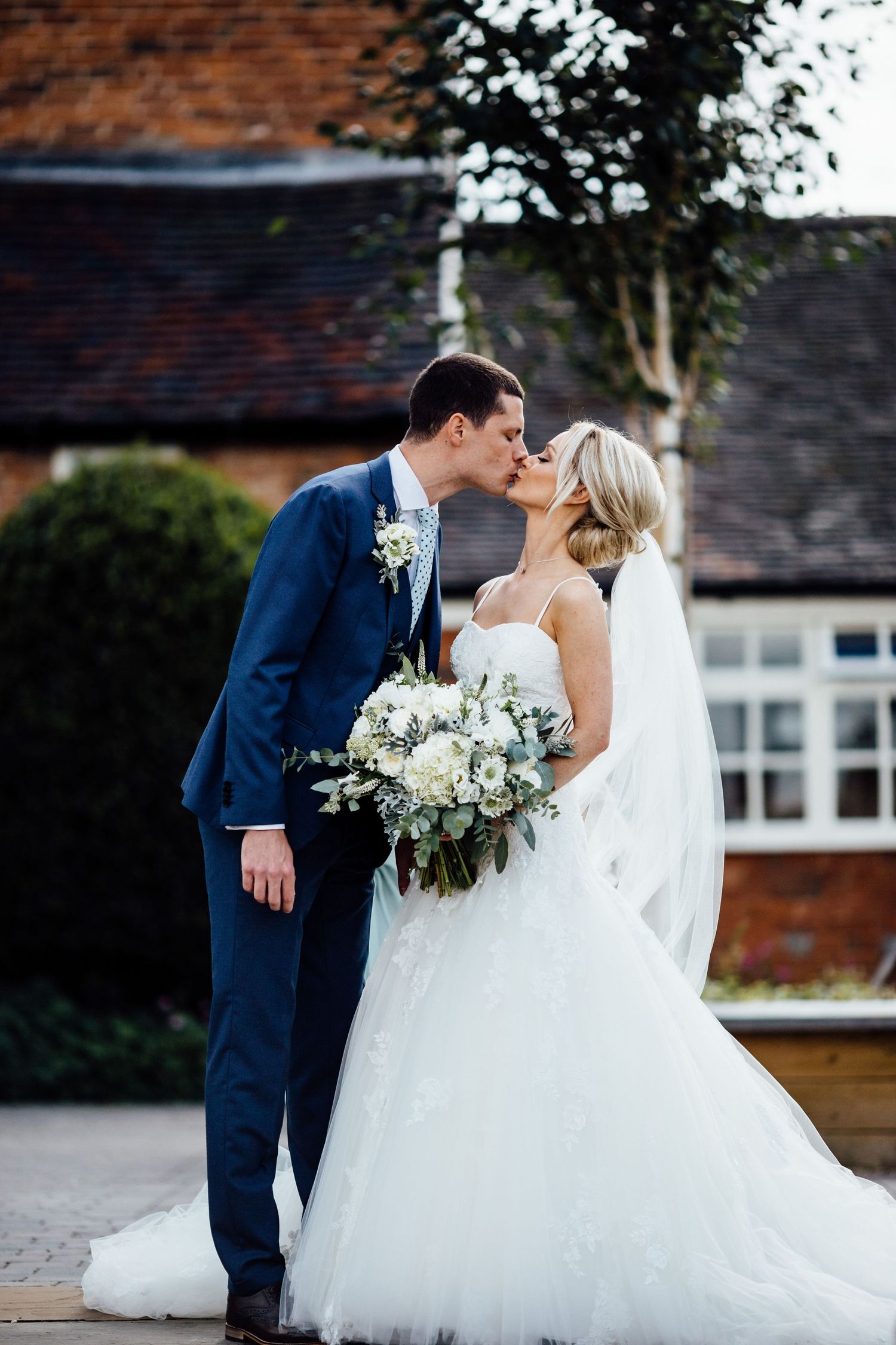 Romantic wedding photography session outside a traditional brick building.