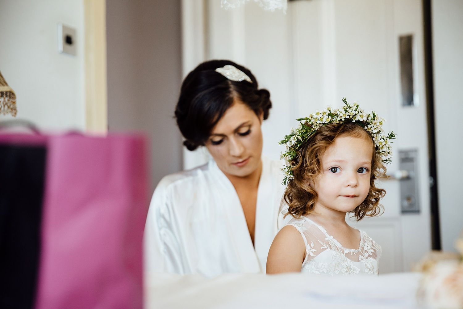 Getting ready scene in a bright room with white robes and lace details.