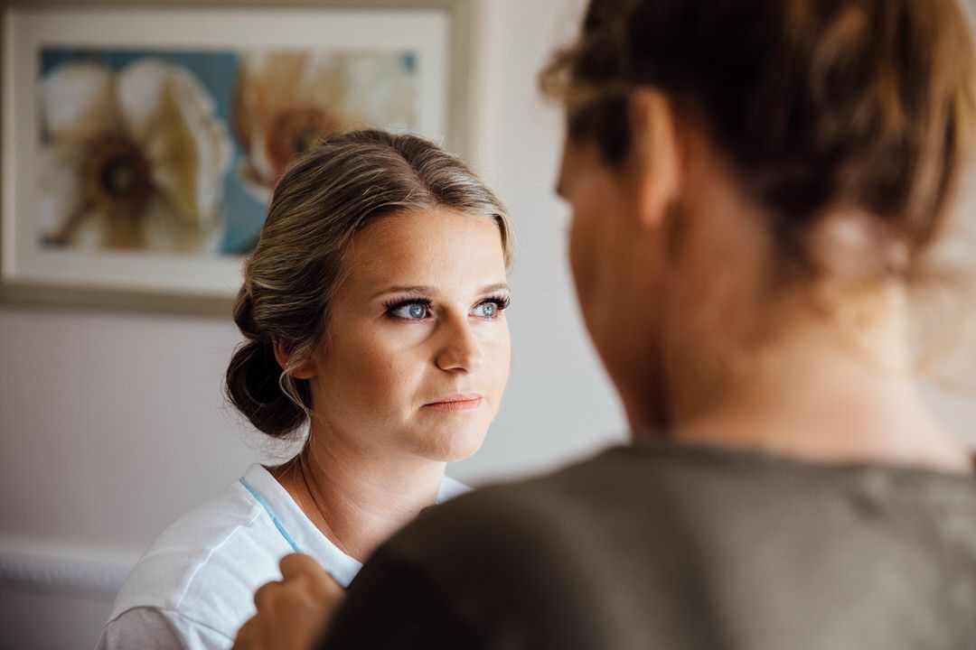 Intimate getting ready moments captured in natural window light.