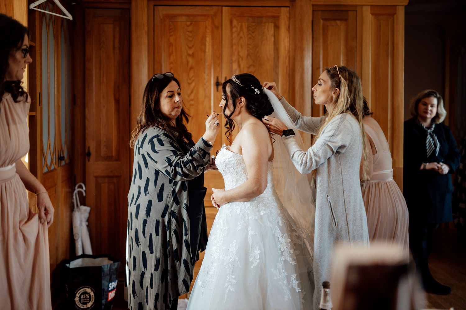 Wedding preparation scene in wooden-paneled bridal suite.