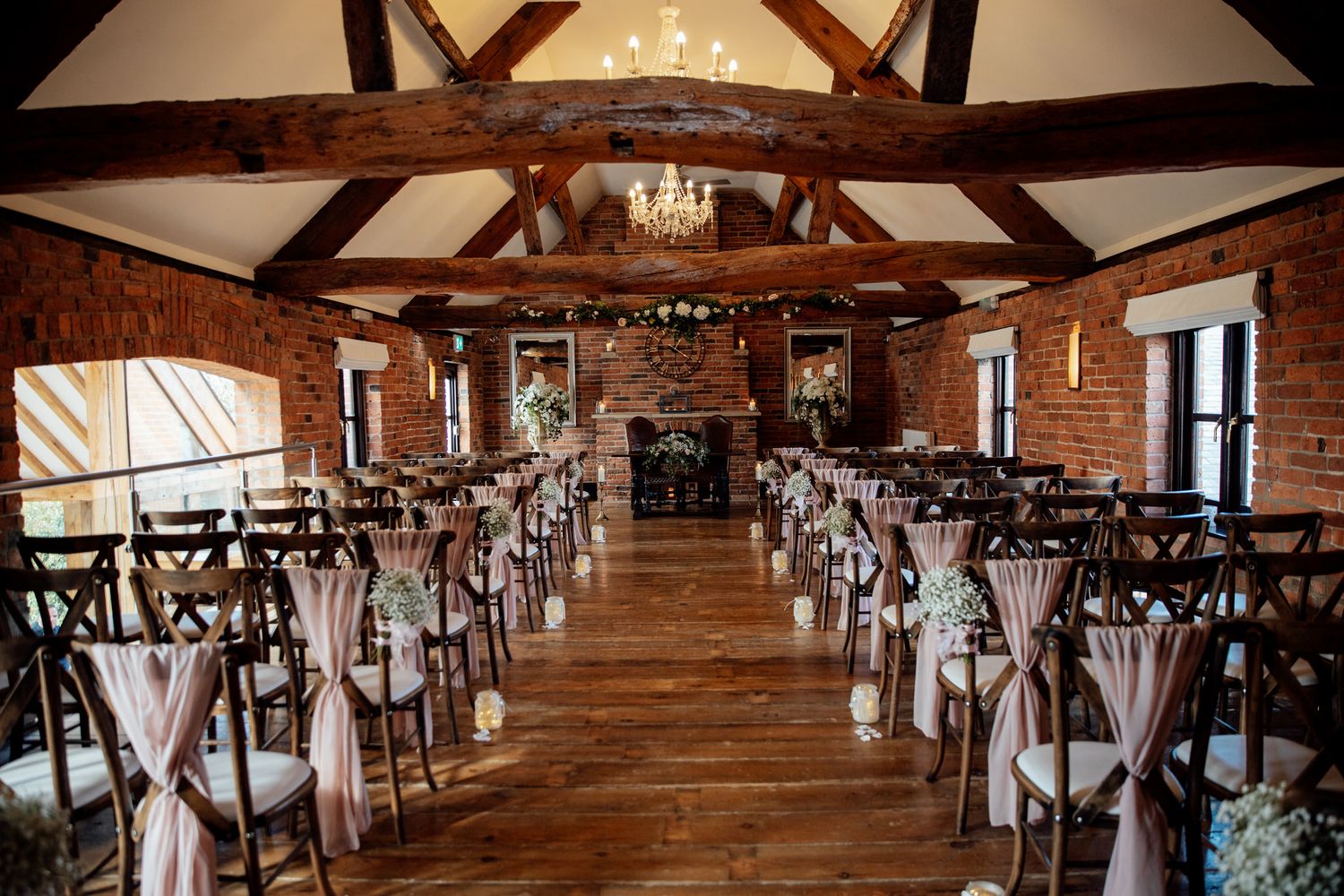 Rustic wedding reception hall with exposed beams and elegant white draping.