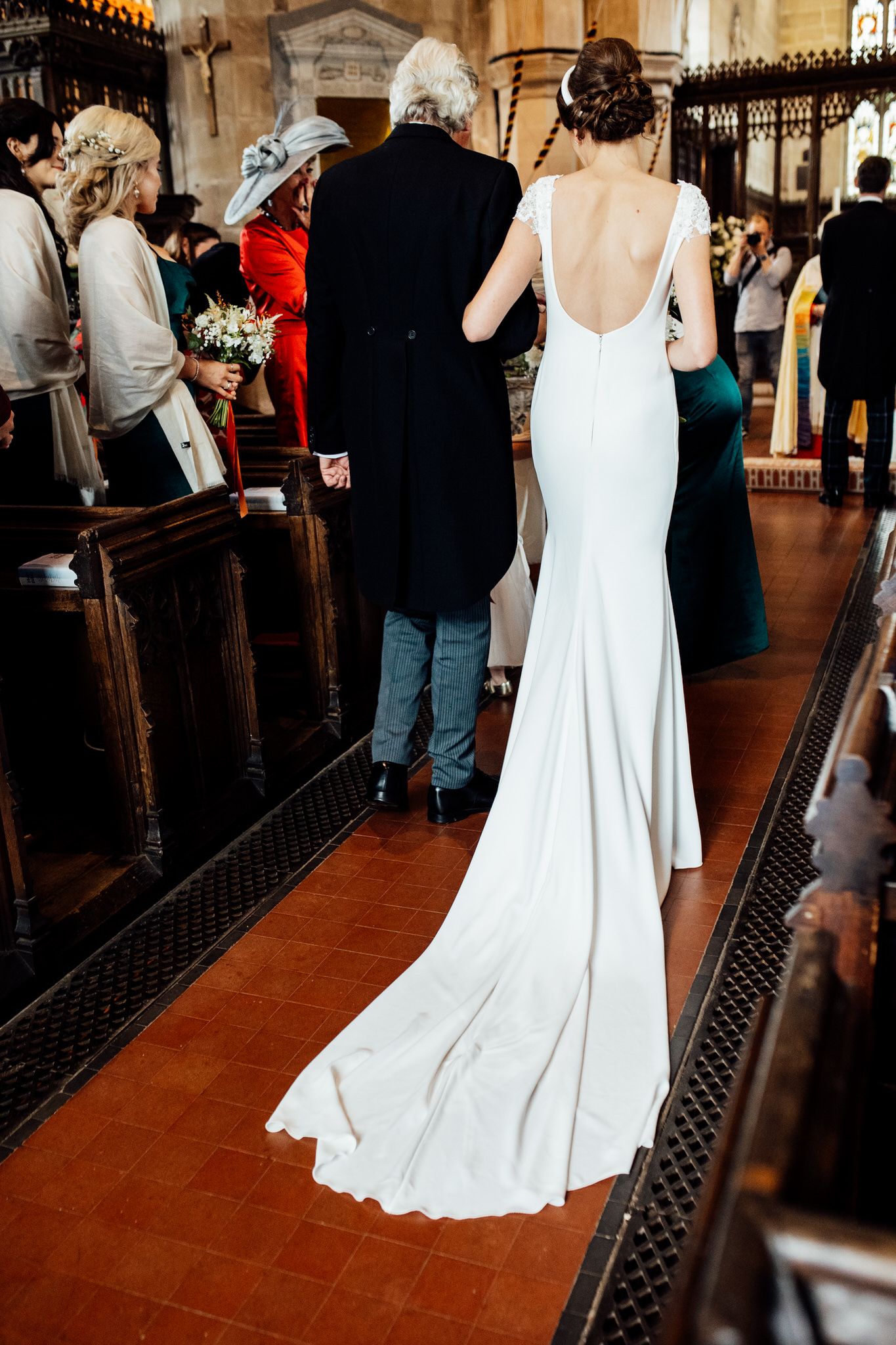 Elegant white wedding dress swirling on a stone church floor during a reception.