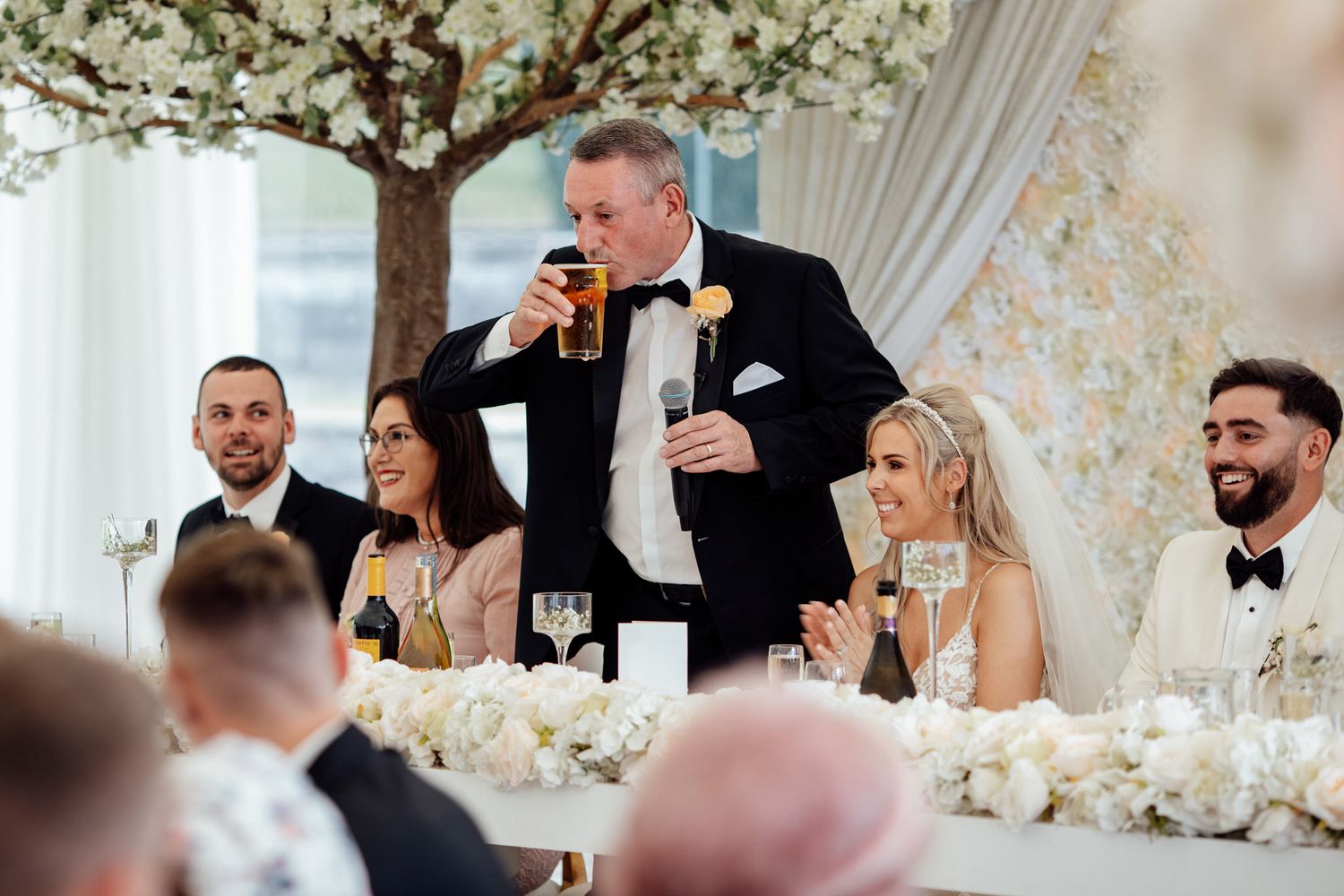 Elegant wedding reception with floral decor and white table settings.