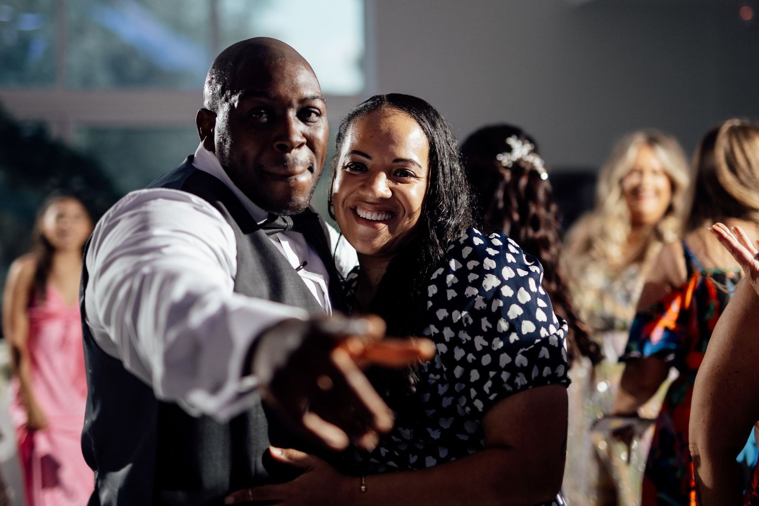 Wedding guests dancing and celebrating at an evening reception.