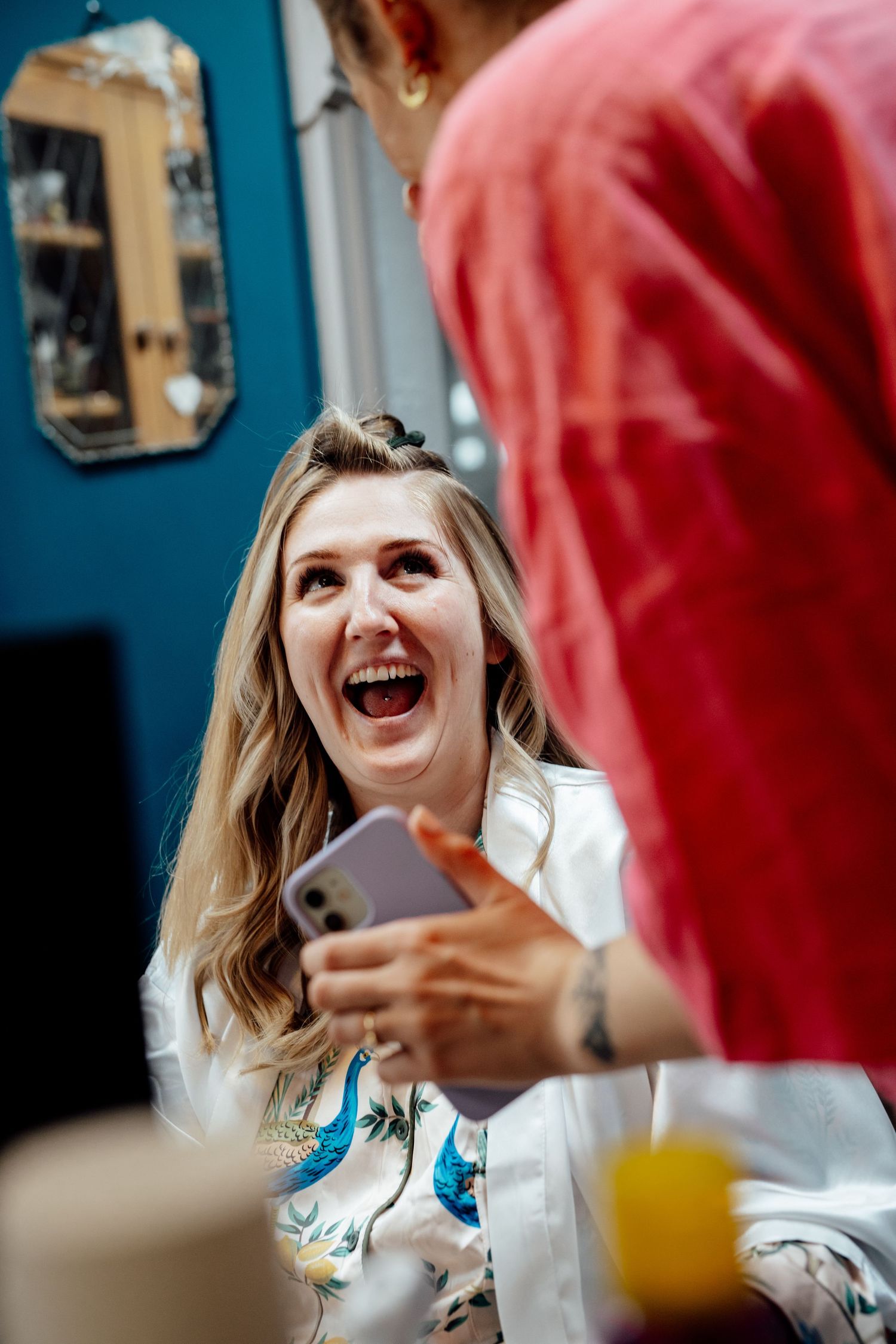 Laughter and joy during a casual gathering with drinks and conversation.