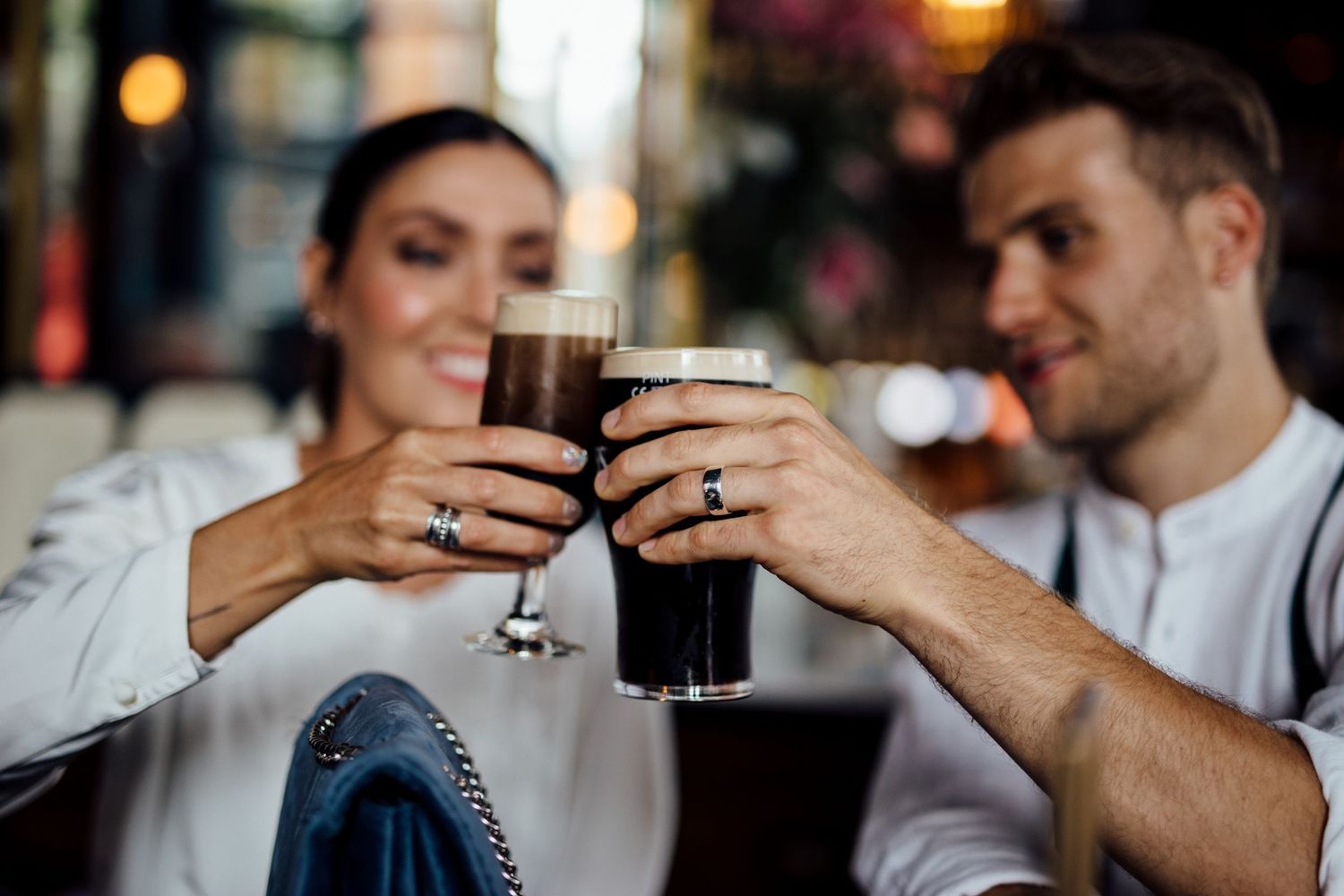 Close-up moments of sharing drinks and conversation in a cozy bar setting.