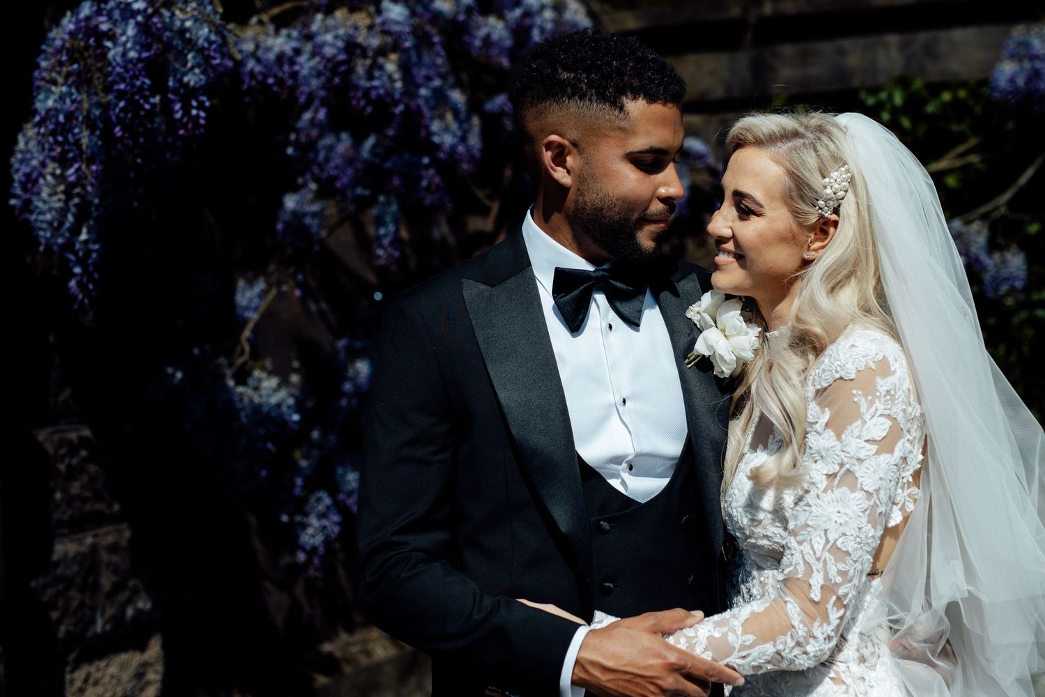Elegant wedding couple shares intimate moments in a romantic outdoor setting with lace details.