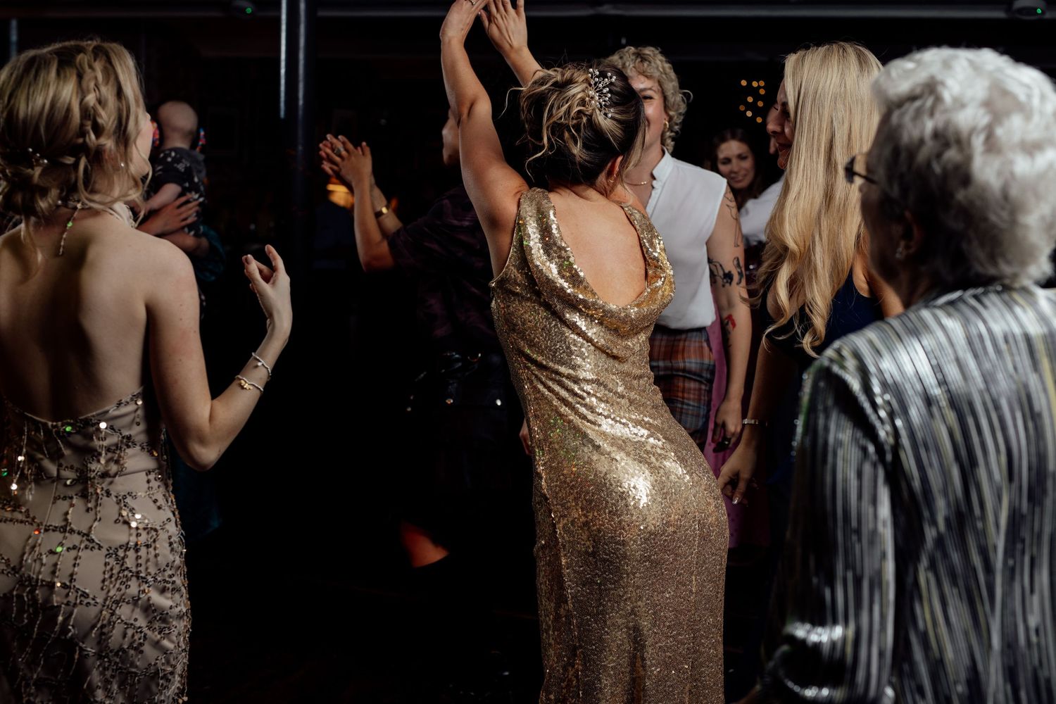 Wedding guests dancing and celebrating in an intimate venue setting.