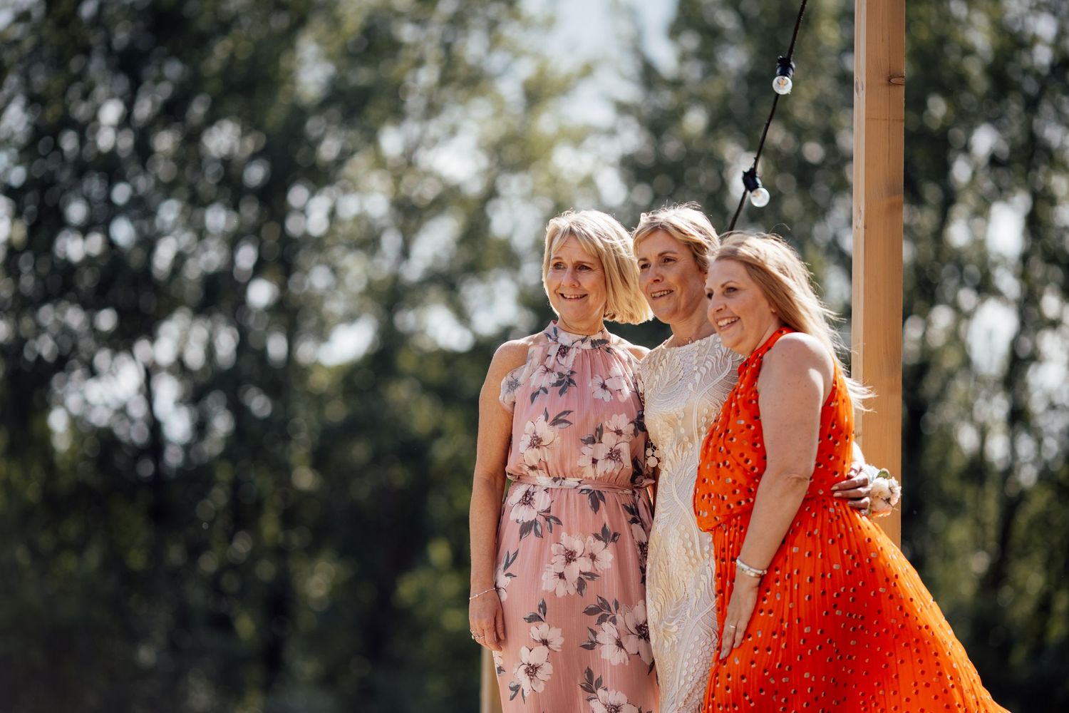 Wedding guests in colorful attire gathered outdoors.