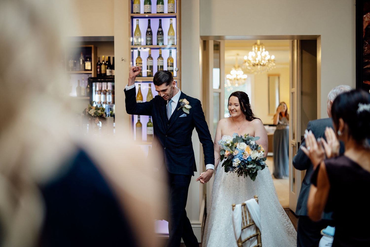 Indoor wedding ceremony venue with elegant chandelier and stained glass windows.