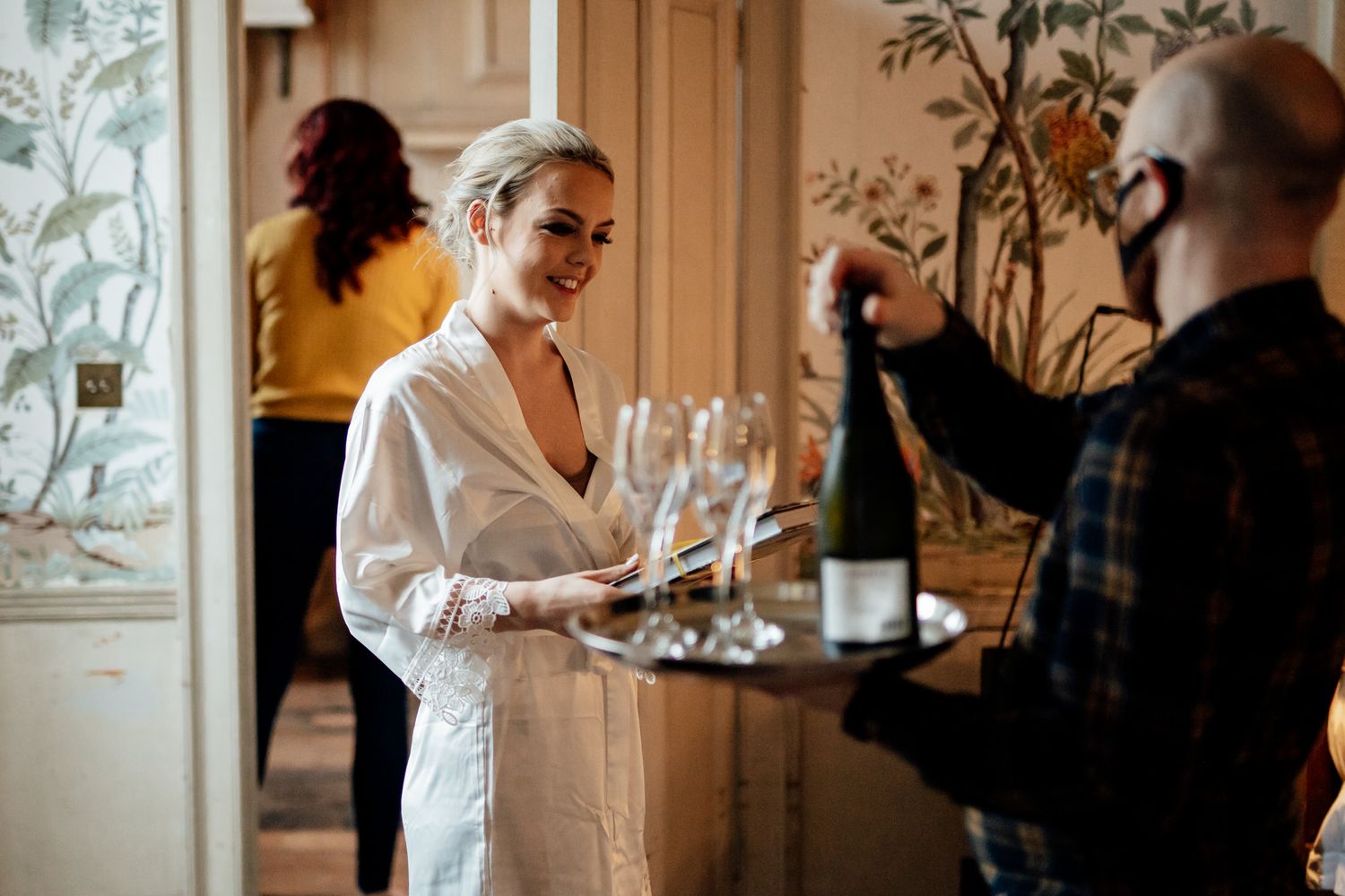 Candid moments captured during wedding preparations in a naturally lit room.