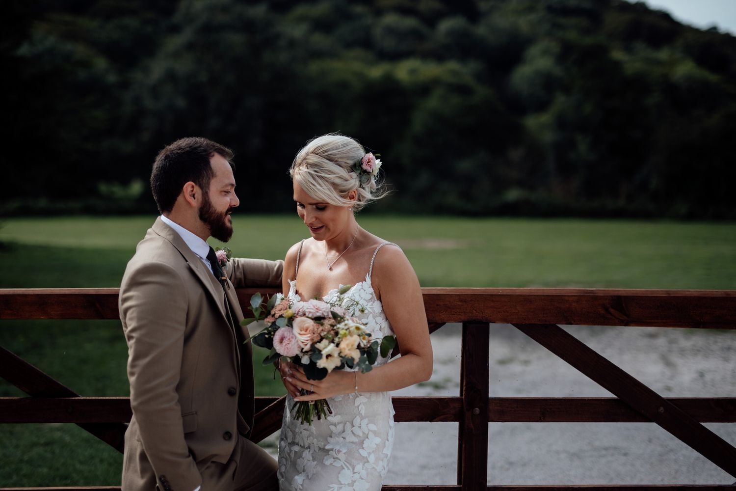 Romantic outdoor wedding portraits captured on a wooden deck during golden hour.