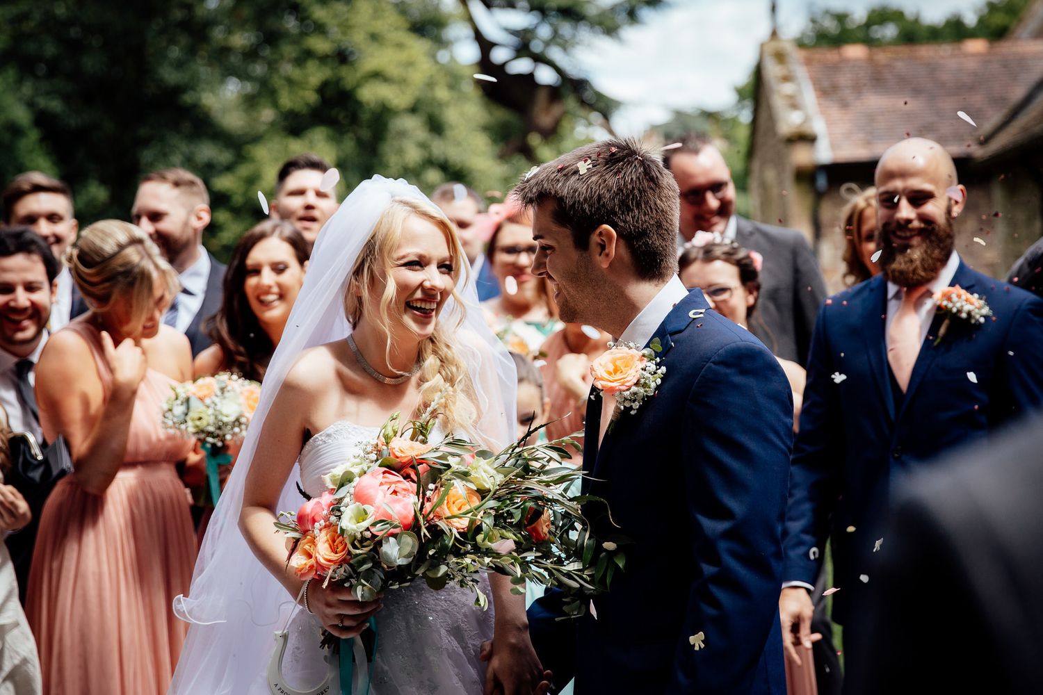 Outdoor wedding celebration with guests mingling in natural daylight.