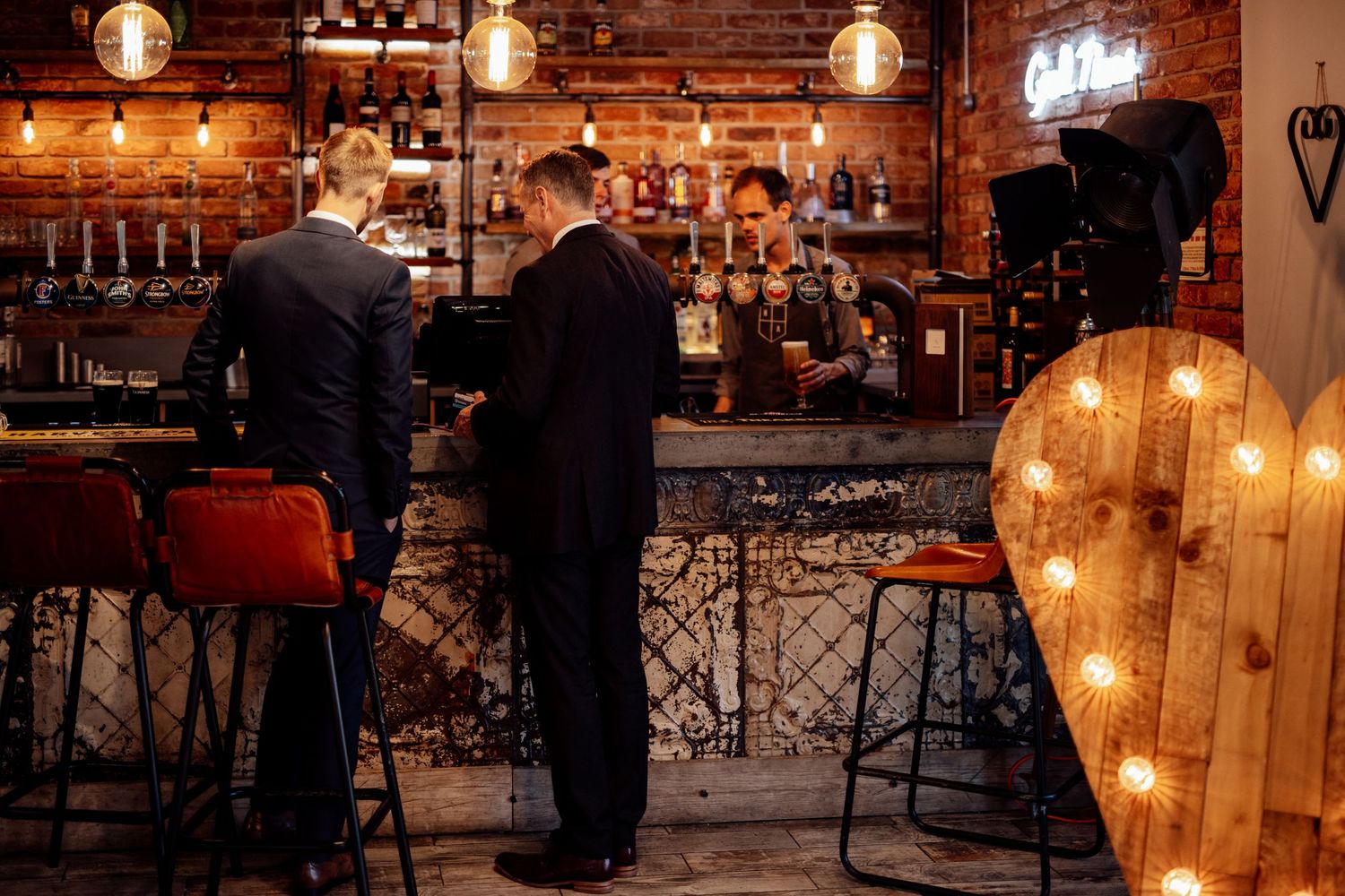 Rustic bar interior with pendant lights and exposed brick creating warm ambiance.