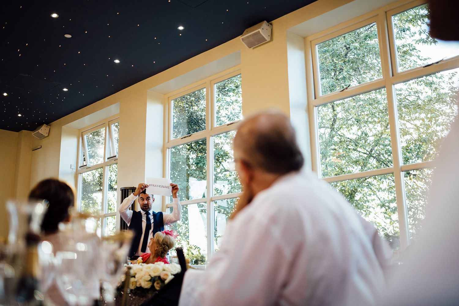 Wedding venue interior with high windows and natural light streaming in.