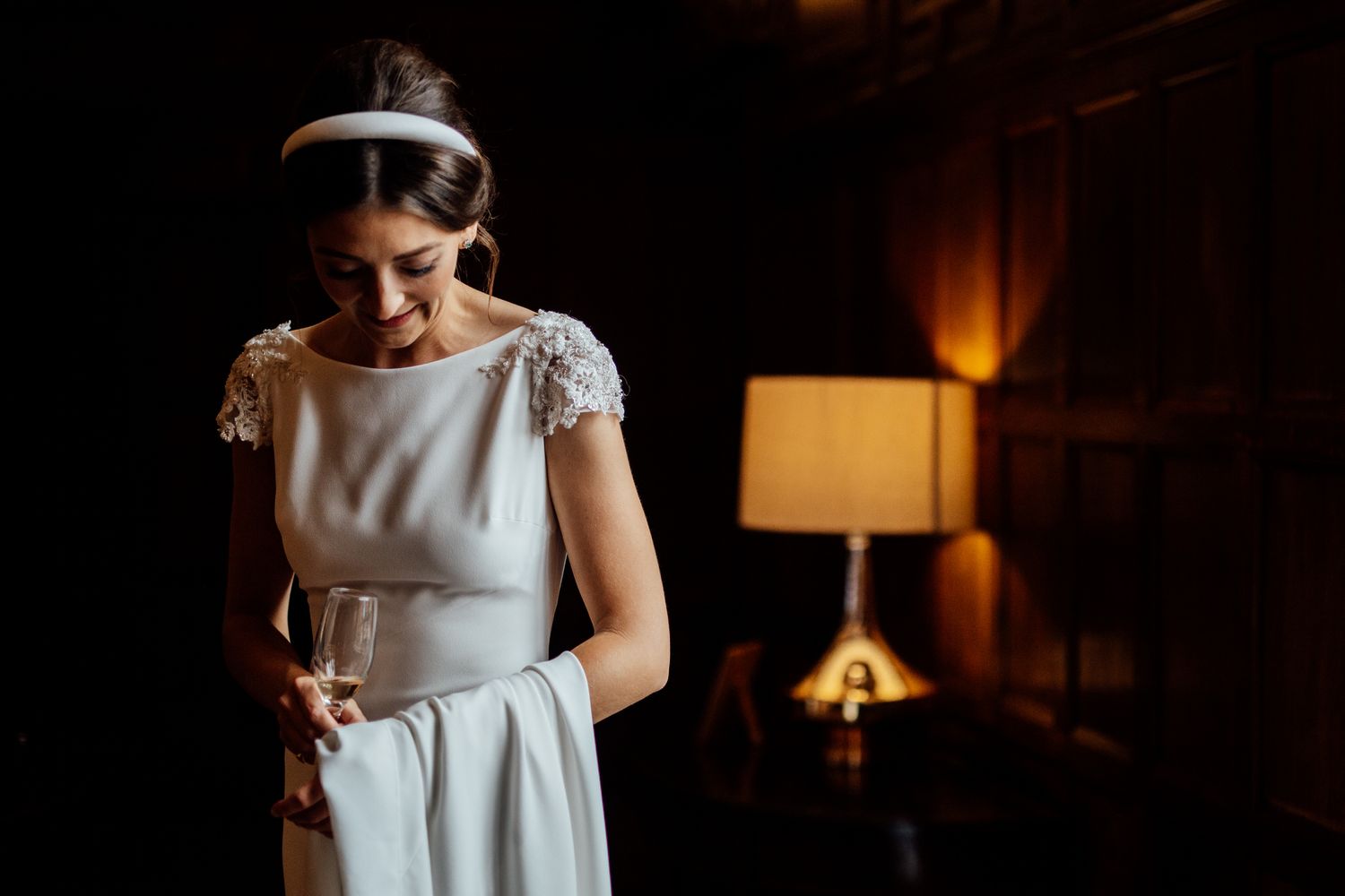 Artistic wedding photography with dramatic lighting and elegant dress details.