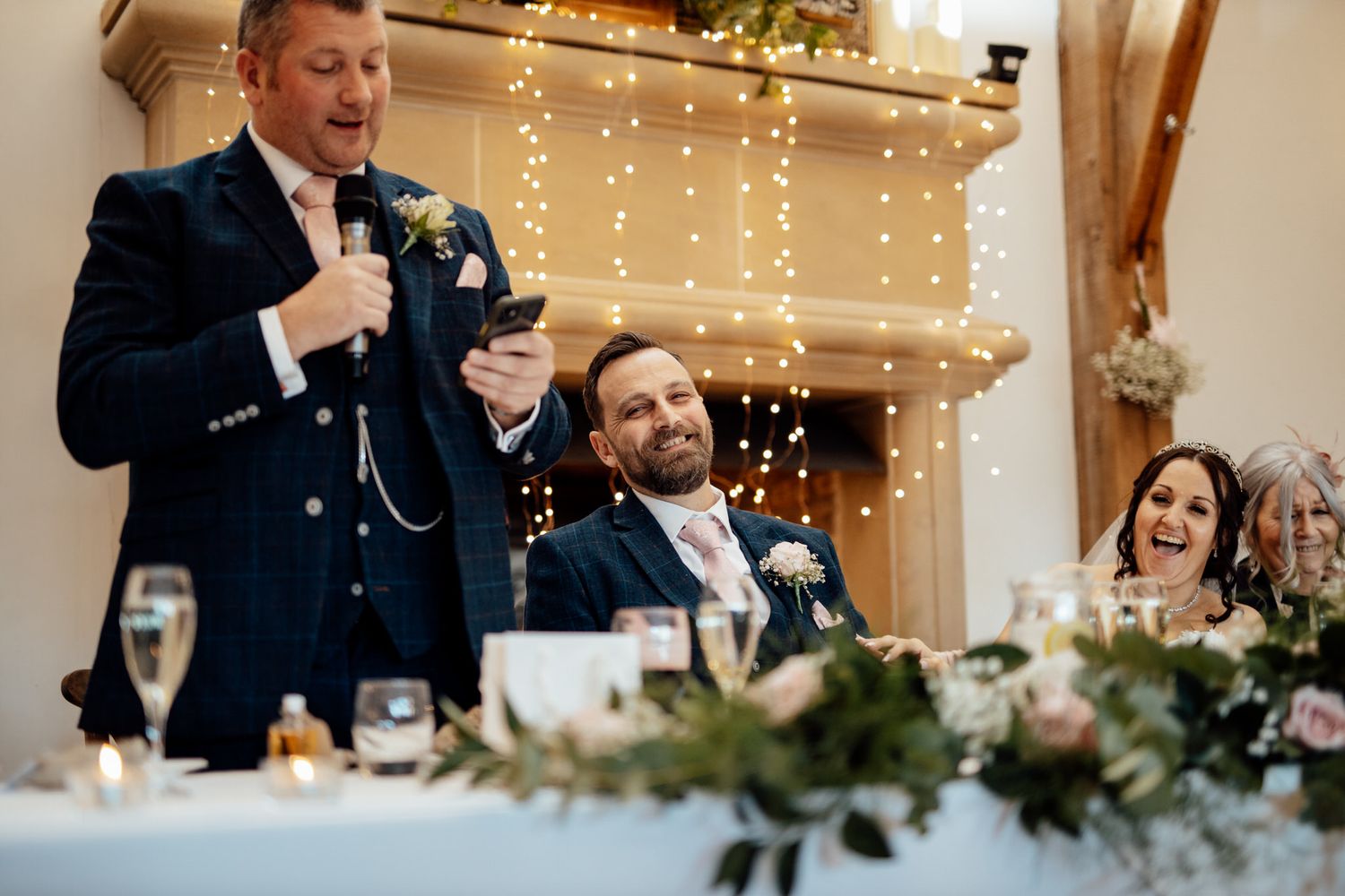 Wedding reception setup with string lights and floral decorations.