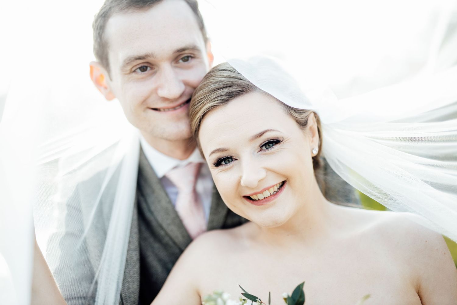 Romantic wedding portrait session with flowing veil in soft natural light.
