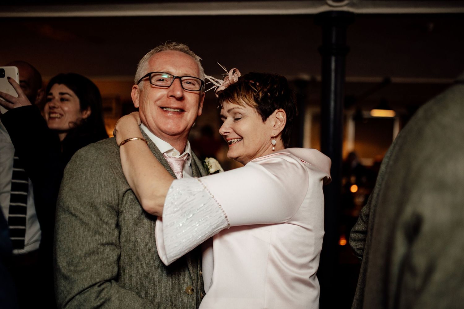 Wedding guests dancing and celebrating together at an indoor reception.