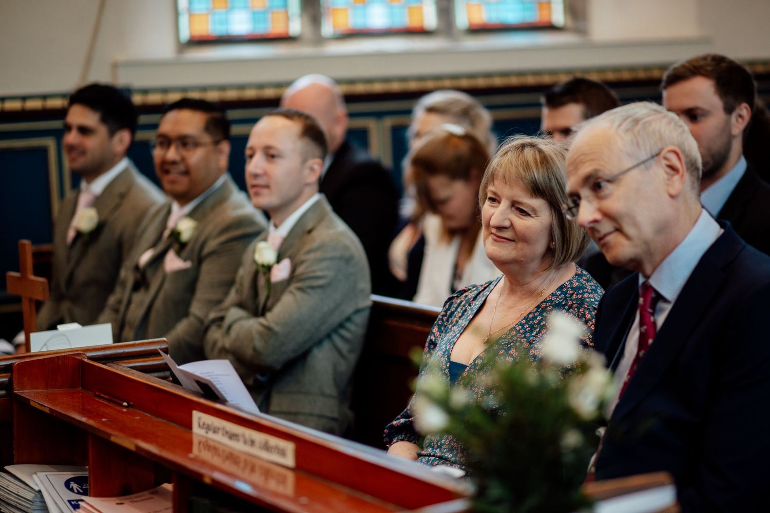 Wedding guests seated in church pews during a ceremony.