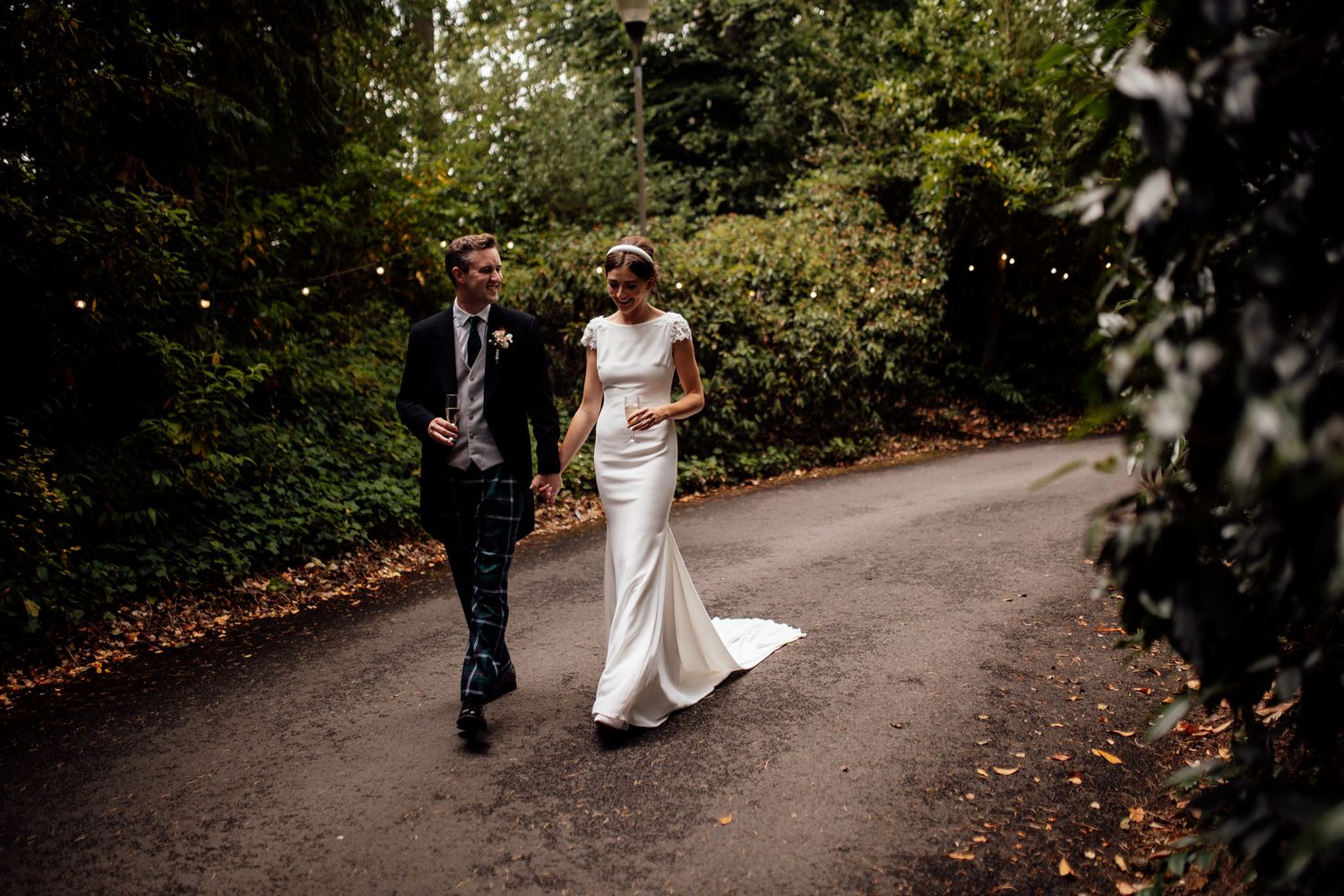 Wedding photography session on a winding path surrounded by lush greenery.