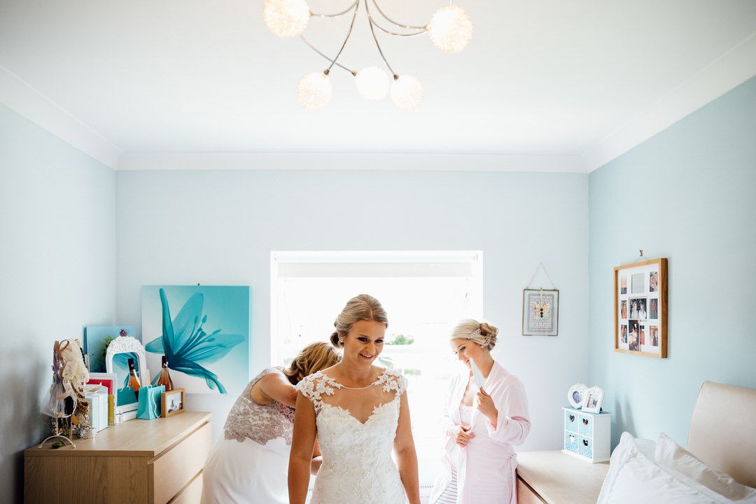 A bridal preparation scene in a light blue room with modern decor and chandelier.